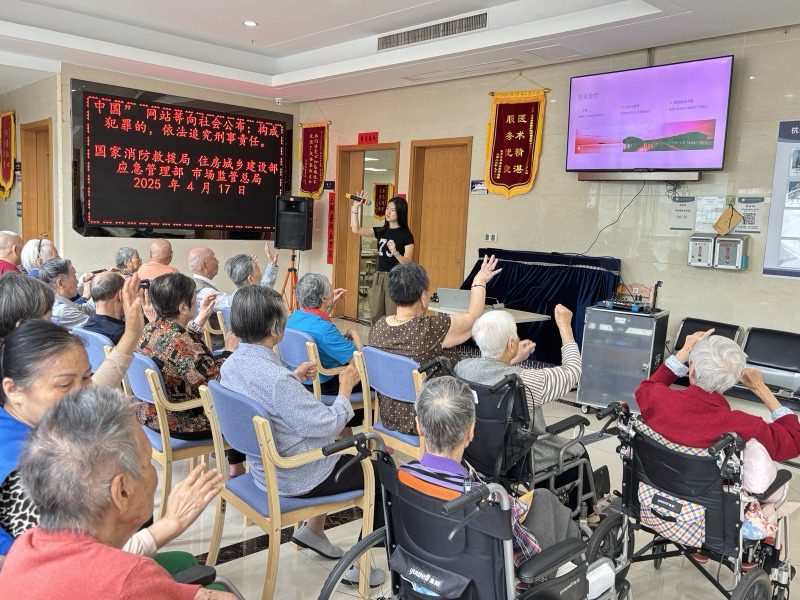 A room of residents watching a Ripple presentation, hands raised along with the music