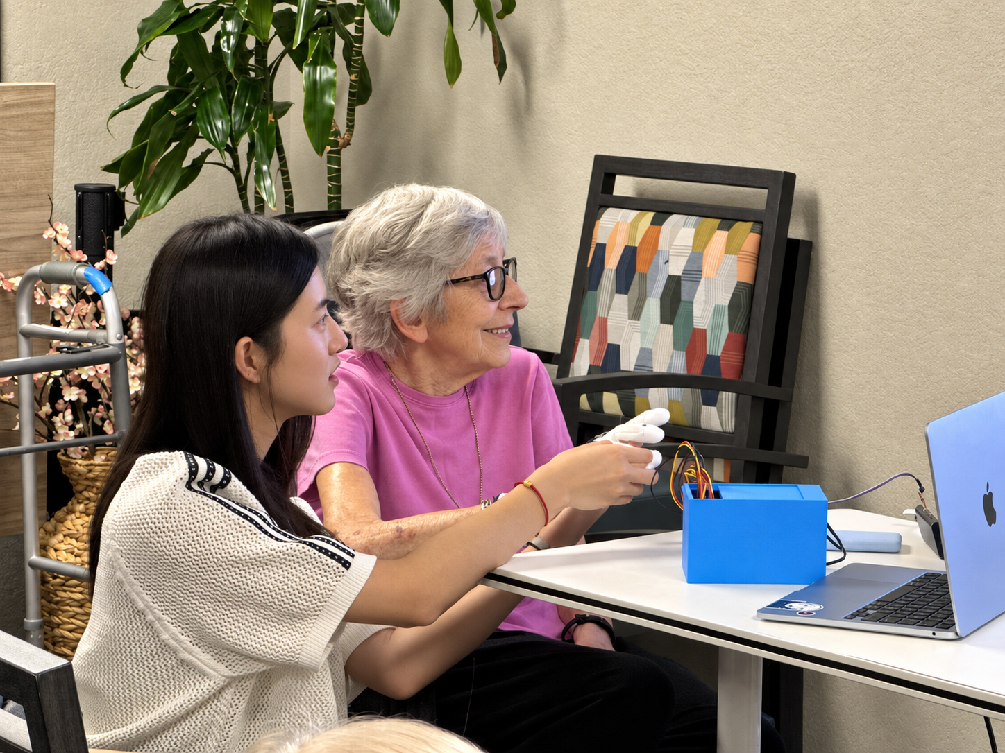 Angela helping an older adult use the Ripple sensor glove to make music