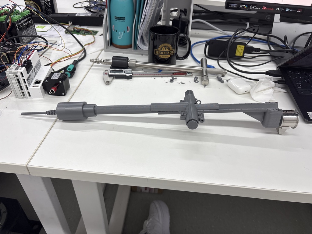 Gray 3D-printed uterine manipulator prototype on an engineering workbench